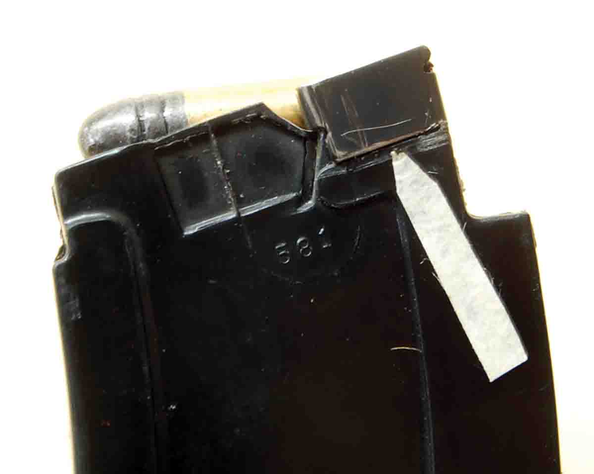 The spring steel clip (see arrow) reinforces the feed rails of the Model 581 magazine. However, rounds still pop out and the magazine is plastic.